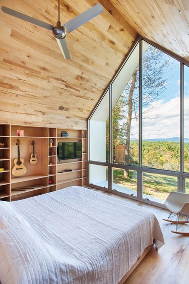small room in cabin with builtin bookcase and forest mountain views large windows