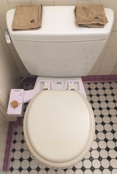 Tushy Classic bidet on Toto toilet in bathroom with black and white floor tile