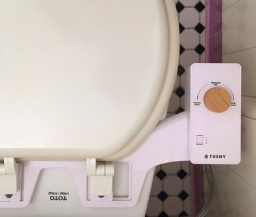 Tushy bidet knob for adjusting water pressure shown on Toto toilet