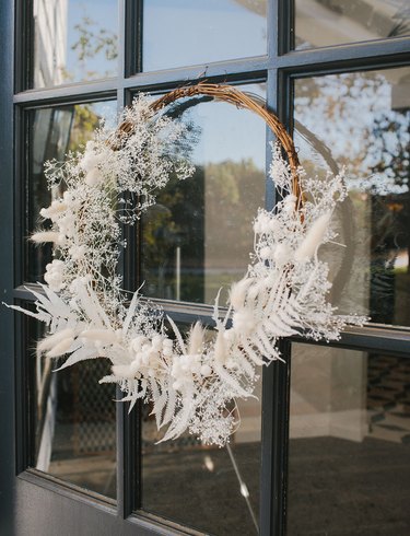 Christmas Door Decorations with Twig wreath with white dried flowers, feathers.