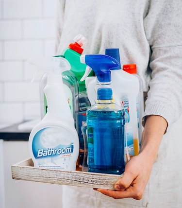 woman holding household cleaners