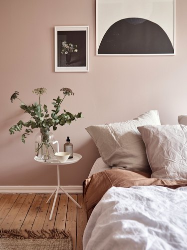 pink and taupe minimalist bedroom idea with wooden floors