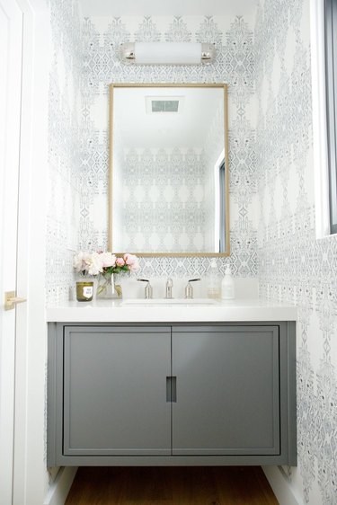 elegant bathroom lighting idea in gray powder room with batik wallpaper