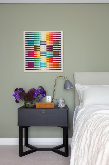 sage minimalist bedroom idea with bold artwork