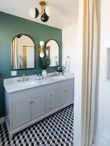 double-sink bathroom lighting idea with wall sconce between two mirrors and semi flush-mount ceiling fixture