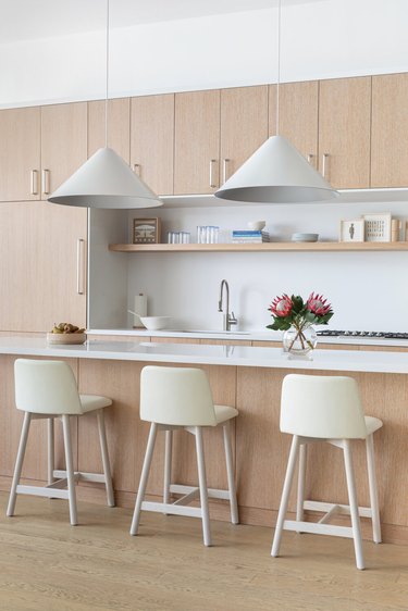 cone-shaped minimalist lighting in neutral kitchen with wood cabinets