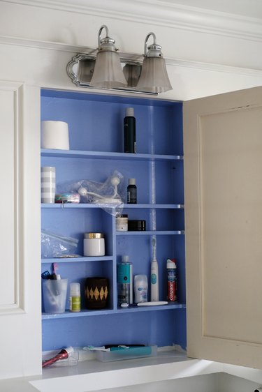 blue medicine cabinet interior featuring personal hygiene supplies