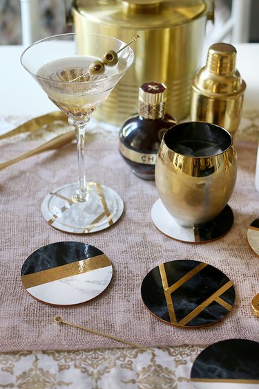 Art deco DIY project with black, gold, and marble coasters among cocktail hour items