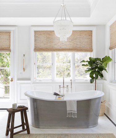 elegant bathroom lighting idea with silver tub and crystal chandelier