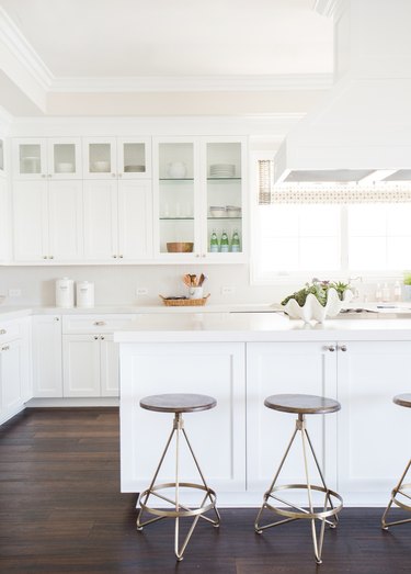 white kitchens with wood floors, white cabinets, and white range hood