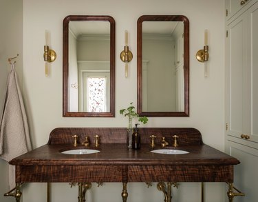 elegant bathroom lighting idea with wood vanity, builtins and slim sconces