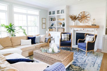 blue and white coastal family room with wicker coffee table ottoman