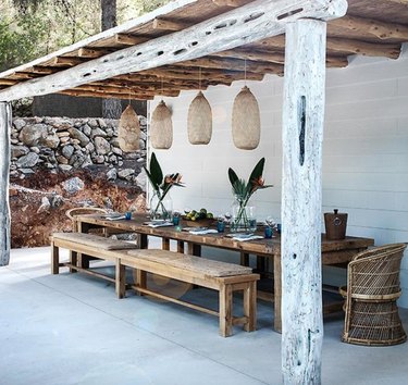 Rustic modern pergola with reclaimed wood beams and wood dining table and benches