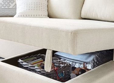 family room storage in cream sectional couch with under seat storage and throw cushion.