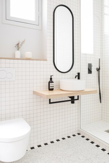 black and white minimal bathroom with floating sink and storage