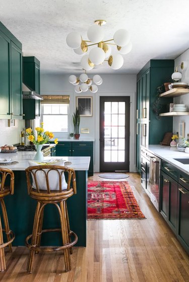 Green boho room with green cabinets and midcentury-inspired lighting