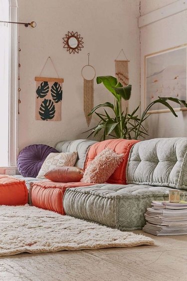 Boho living room full of colorful floor cushions and furry carpet