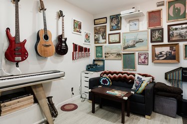 Music room and gallery with musical instruments and artwork on the walls and floor.