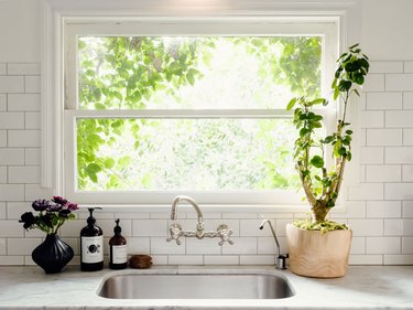 kitchen sink with wall mounted faucet and white subway tile backsplash