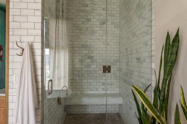 shower with light subway tile  wall and bench