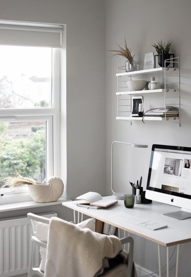 white home office idea with desk, chair, and wall shelf