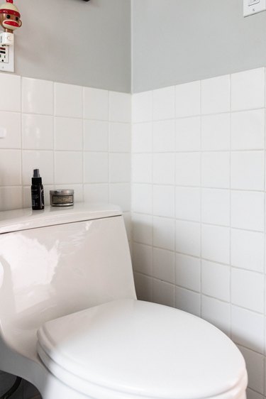 close up of toilet with tile backsplash