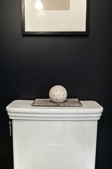 close up of top of toilet and dark blue wall