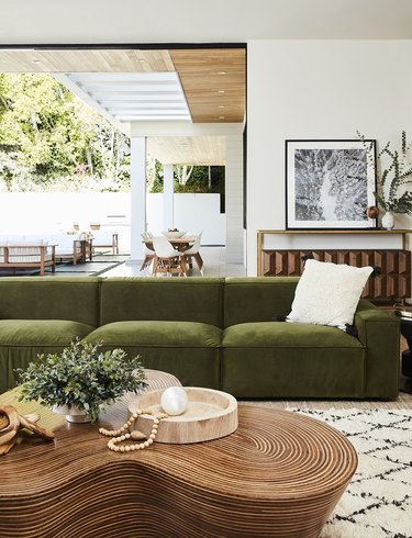 boho green room with luxe velvet sofa and wood coffee table