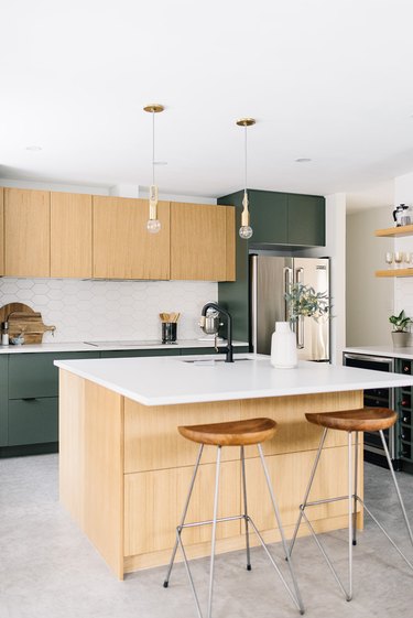 Concrete minimalist flooring in light wood and green modern kitchen