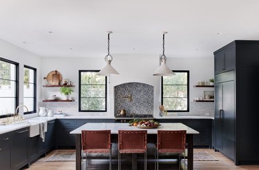 dark kitchen cabinets with light floors and tile stove backsplash