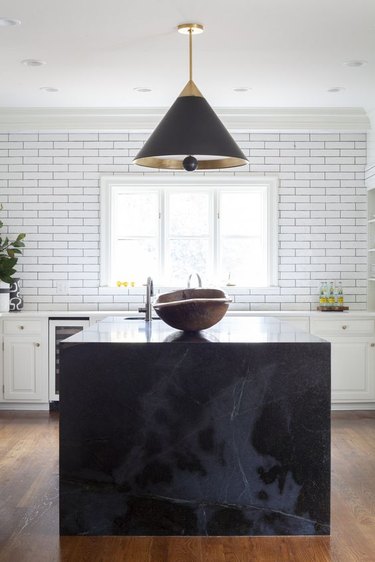 black and gray marble kitchen island with black cone-shaped pendant lights