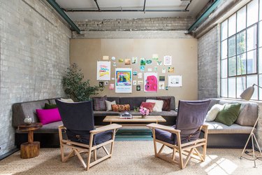 family room furniture with pink pillows and exposed brick wall
