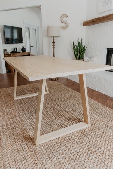 DIY minimalist dining table with angular legs and a wood finish