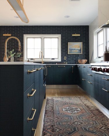 dark kitchen cabinets with light floors with blue subway tile backsplash and light wood floors