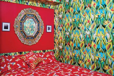 pattern filled bedroom with tropical wallpaper and ornate bedspread