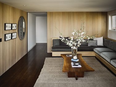 small living room idea with wood panelling on walls and built-in seating
