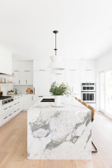 white kitchens with wood floors and marble waterfall island