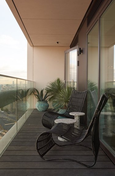 minimalist balcony idea with two black chairs and plants