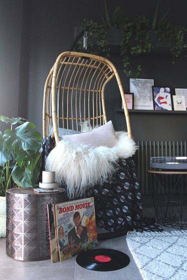 hanging rattan chair in dark gray living room corner idea