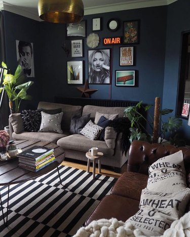 dark industrial living room idea with navy blue walls and striped area rug