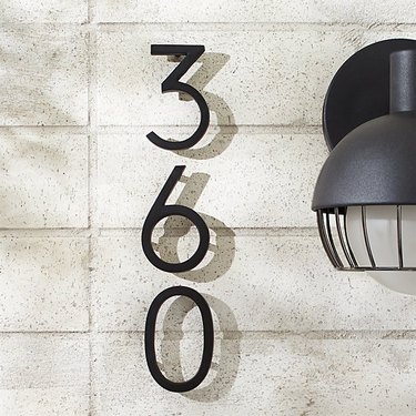 modern house numbers on white brick siding by CB2