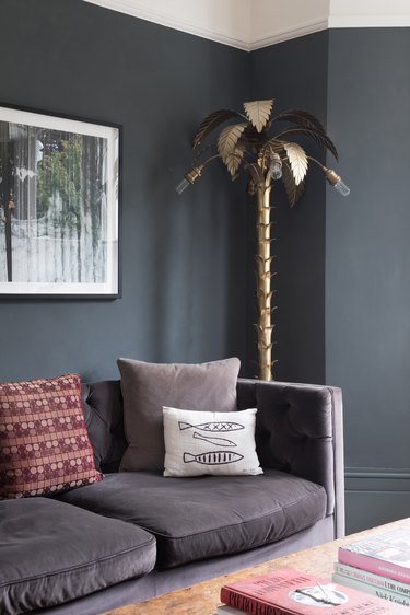 dark gray living room corner idea with statement gold palm tree light