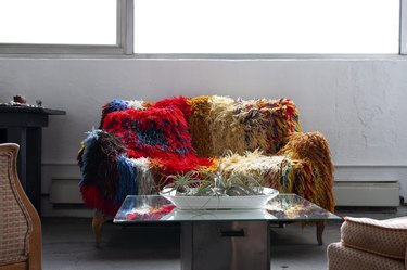 Colorful afghan covered couch with mirrored table