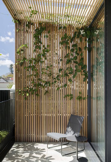 minimalist balcony idea with wood slat frame and modern chair and side table