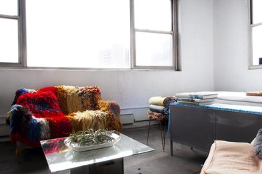 Brooklyn loft with white walls, large windows, and colorful couch