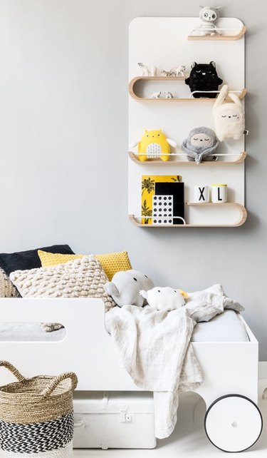 minimalist toy storage idea with wall shelving near bed