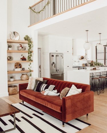 Rust sofa in white living room with black and white living room