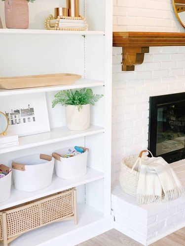 Family room toy storage in white rope baskets and a cane container