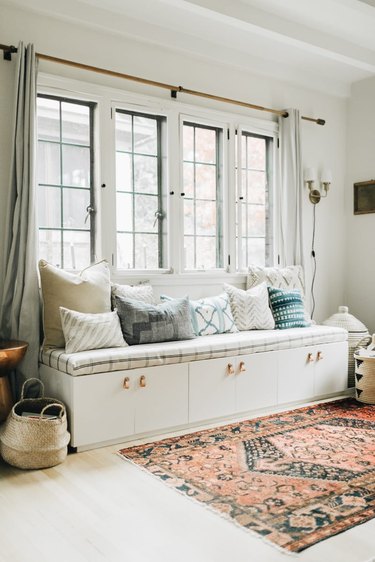 Family room toy storage in a white DIY storage bench under window