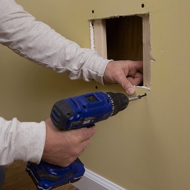 Backer strips in drywall hole.